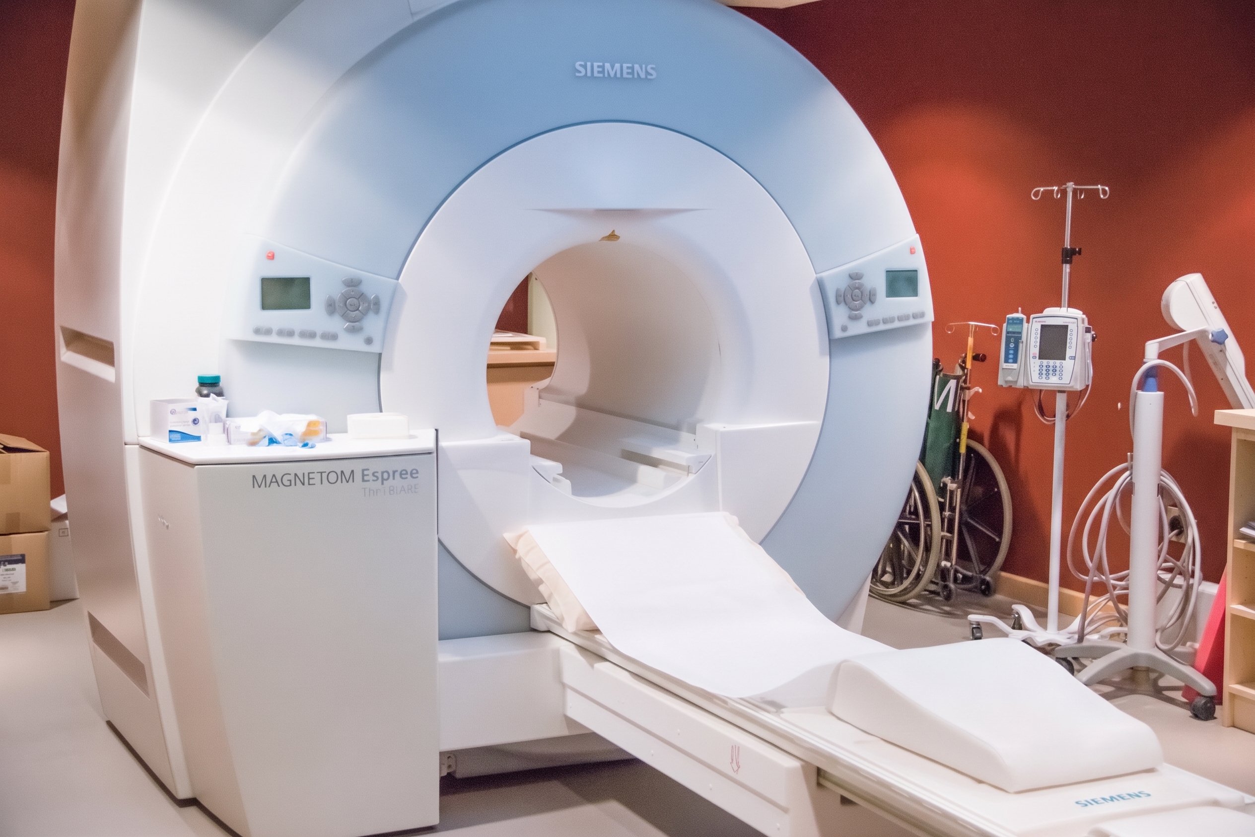 A view of an empty CT scanner machine positioned in an imaging room.